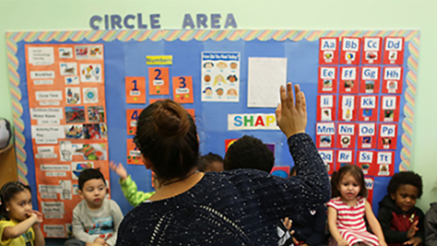teacher raising hand in classroom