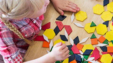 Child playing with wood shapes