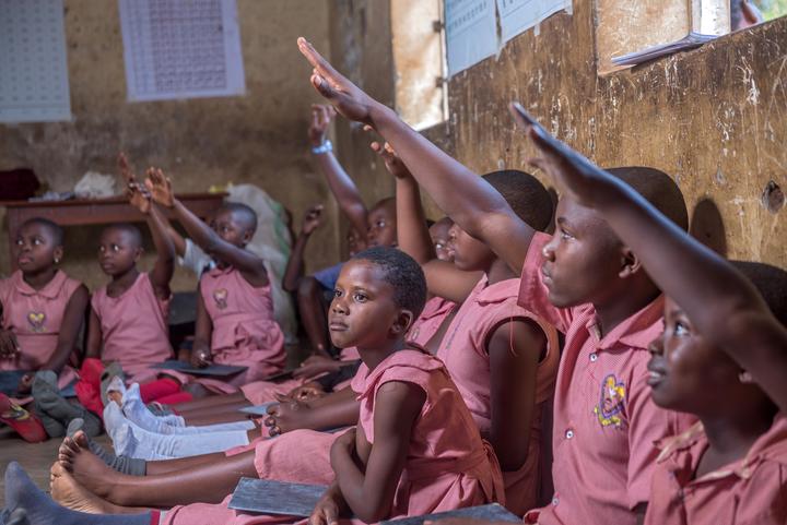 A group of school children raising their hands